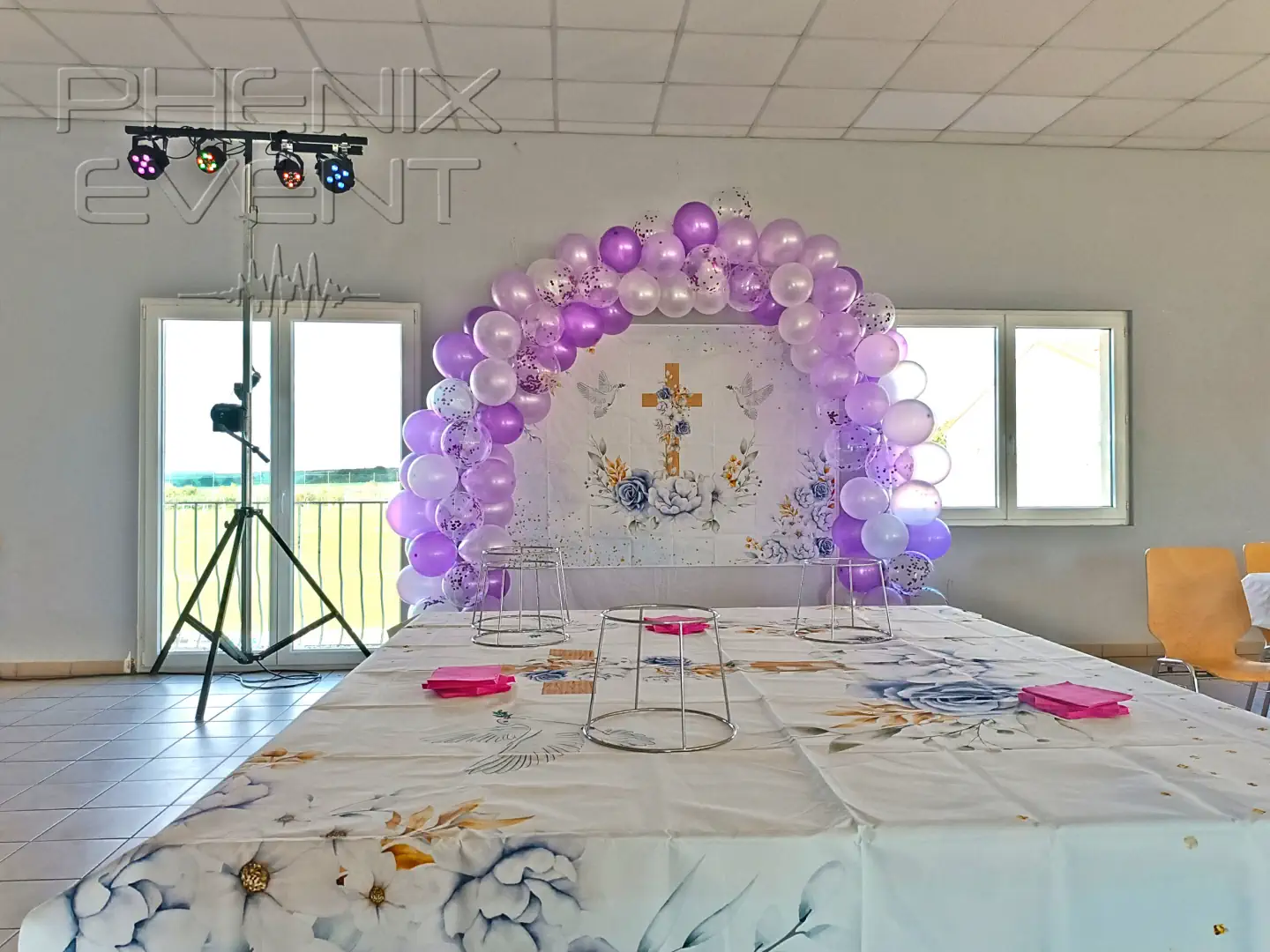 un trépied robuste avec plusieurs projecteurs déployé à côté d'une arche de ballons