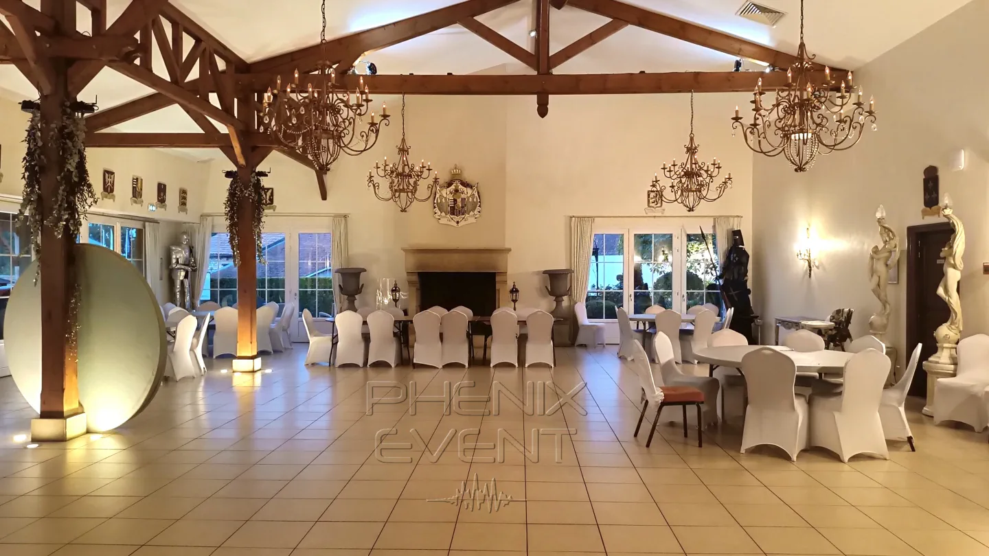 la salle des fêtes de la grange de condé ornée de lustres, d'armoireries et de chevaliers en armures dans chaque coins