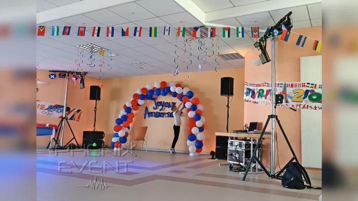 matériel de sonorisation 1900w Stack et d'éclairage Pack Fête 1 installés de parts et d'autres d'une arche de ballons tricolore. Un enfant attache un ballon.