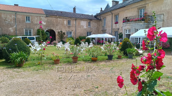 Vue de la cour du château de Ville-au-Val avec les chaises, mange-debout et tonnelles installés