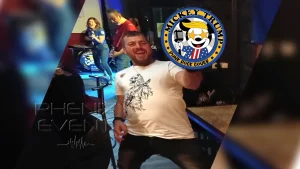 un spectacteur venu voir Mickey Trump fait de la Air Guitare. Le bassiste et la chanteuse du groupe sont en arrière plan.