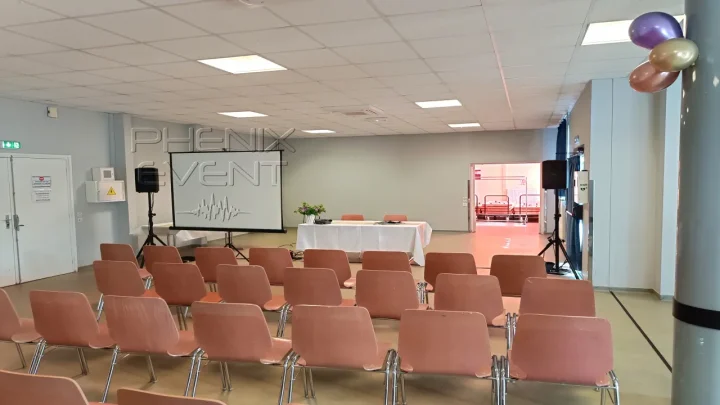 Vue générale de la salle de conférence de l'association L'Espoir à Saint-Avold, avec les enceintes sur trépieds et les chaises prêtes à accueillir les participants