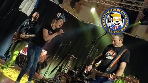 Mickey Trump en train d'interpréter Cover me in Sunshine sur la scène de la salle de la mairie de Fillières.