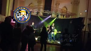 Le groupe Mickey Trump en pleine reprise de Hot N Cold sur scène à Fillières, lors du concert caritatif pour Sclérolife. La chanteuse est au micro, entourée des musiciens, devant un public enthousiaste