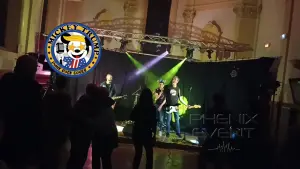 Le groupe Mickey Trump en pleine reprise de Hot N Cold sur scène à Fillières, lors du concert caritatif pour Sclérolife. La chanteuse est au micro, entourée des musiciens, devant un public enthousiaste
