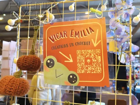 Accrochée sur une grille, l'affiche promotionnelle de Vicar Emilia au salon du Geek 2024 de Saint-Avold