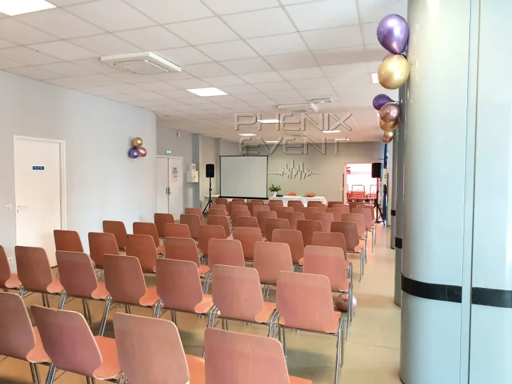 Vue latérale du système de sonorisation avec les chaises, l'écran, la table fleurie et des ballons décoratifs