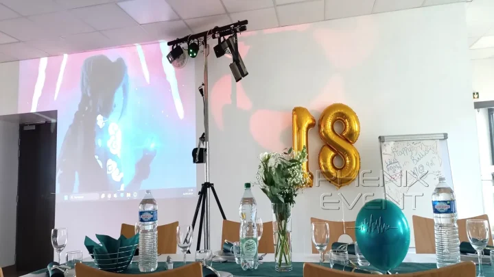Test du vidéoprojecteur dans la salle décorée : image projetée sur le mur, module du Pack Fête 1, ballon 18 ans et tables décorées
