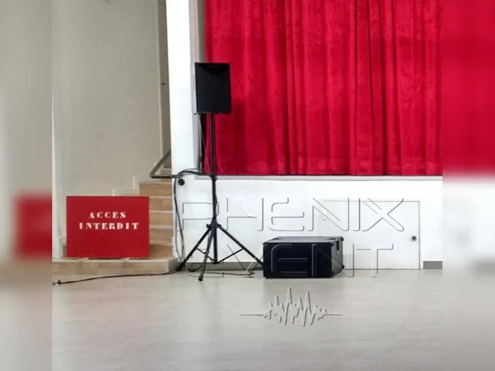 enceinte sur trépied et caisson de basses posé au sol installés devant la scène, côté jardin