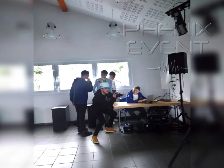 Un pote désigne le héros du jour avec système sono en arrière-plan