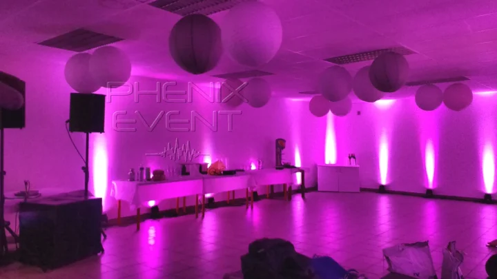 Vue d'ensemble de la sono 1500w Phenix Event installée dans un coin de la salle et des projecteurs au sol éclairent les murs en rose-violet