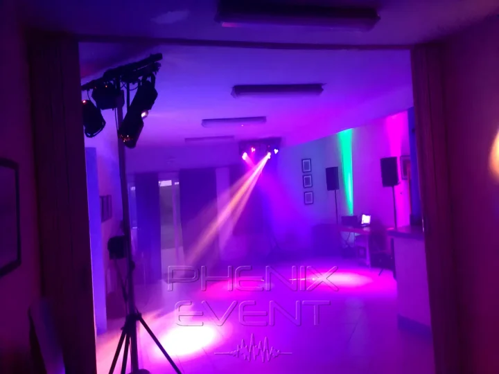 Vue d'ensemble du matériel sono et lumière Phenix Event installé, des faisceaux lumineux colorent les murs et la salle