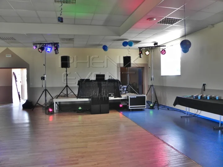 Trépieds des jeux de lumière du Pack Fête 1 installés de chaque côté de la petite scène et projecteurs deco alignés au sol