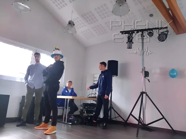Jeunes en pose devant la table DJ et jeux de lumière Phenix Event déployés.