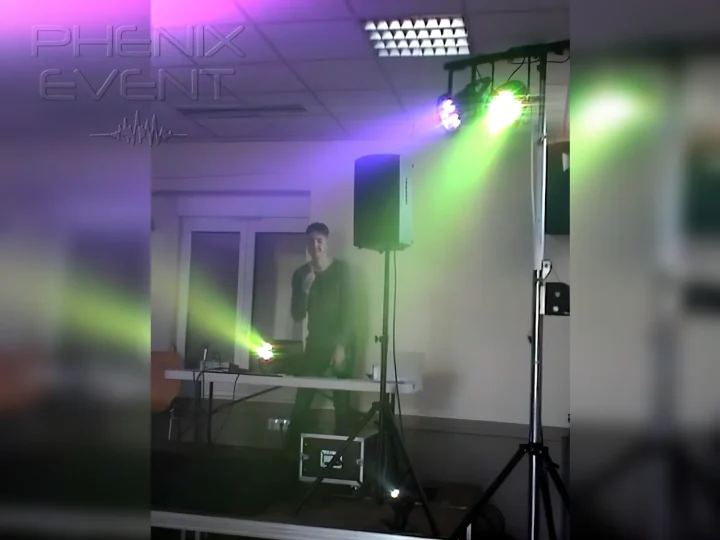 Guillaume aux platines, pouce levé et sourire aux lèvres, éclairé par les jeux de lumière Phenix Event