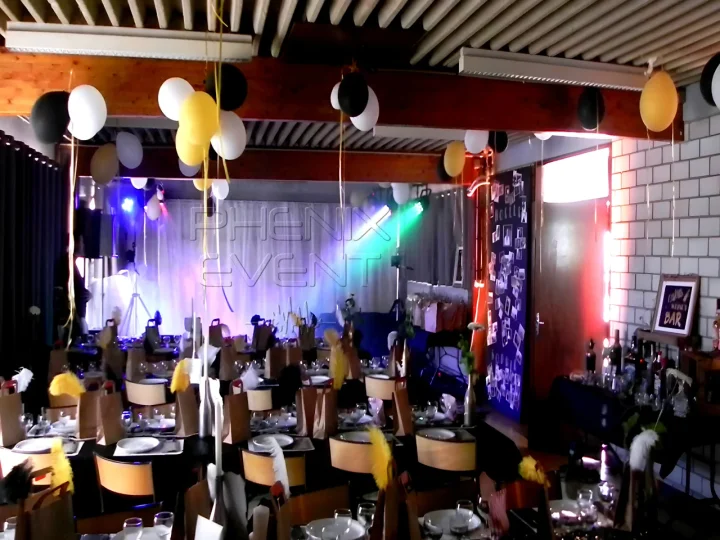 Vue d'ensemble de la salle de mariage à Courcelles-Chaussy avec les tables dressées et le matériel sono et lumière installé au fond