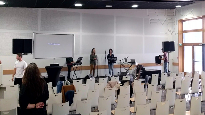 Salle du Konacker à Hayange vue de face avec sono 4000w installée, chanteuses sur scène et parterre de chaises
