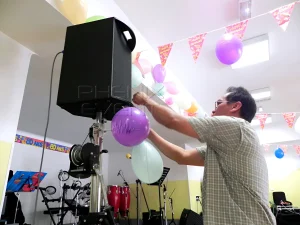 Client accrochant des ballons sur les enceintes Phenix Event pour l'anniversaire