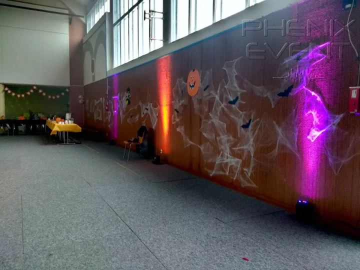 Projecteurs LED au sol, contre le mur du gymnase, faisceaux dirigés vers le haut