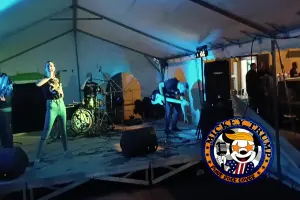 mickey trump sur la scène de la kermesse de godbrange. La chanteuse sourit avec un verre de bière à la main.