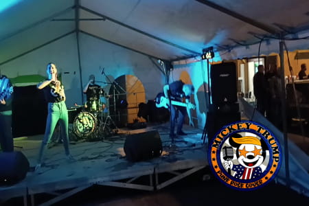 mickey trump sur la scène de la kermesse de godbrange. La chanteuse sourit avec un verre de bière à la main.