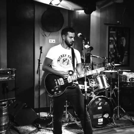 le guitariste des mickey trump en train de jouer de façon très concentrée