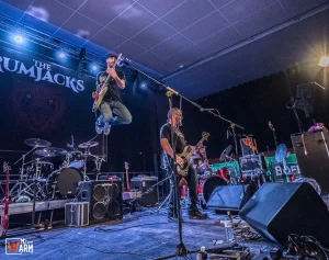 Paul, le guitariste chanteur, fait un saut très haut avec sa guitare