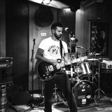 le guitariste des mickey trump en train de jouer de façon très concentrée