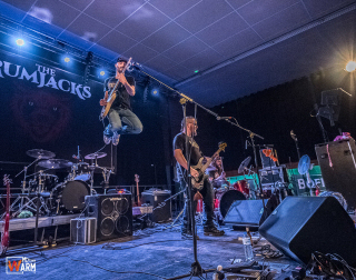 Paul, le guitariste chanteur, fait un saut très haut avec sa guitare